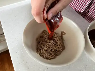 메밀면에 매콤 비빔장을 짜 넣는 모습