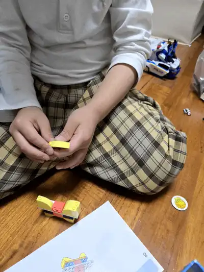 설명서를 보며 브릭을 끼우는 아이의 손